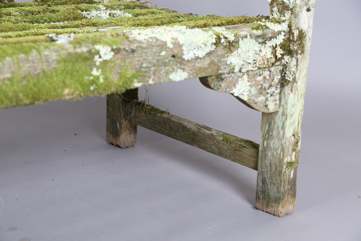 A 20th century teak garden bench, covered in green lichen, height 81cm, width 182cm, depth 70cm. - Image 5 of 11