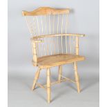 A 20th century provincial softwood Windsor armchair with spindle back and solid seat, height