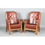 A pair of early/mid-20th century oak framed armchairs, upholstered in buttoned brown leatherette,