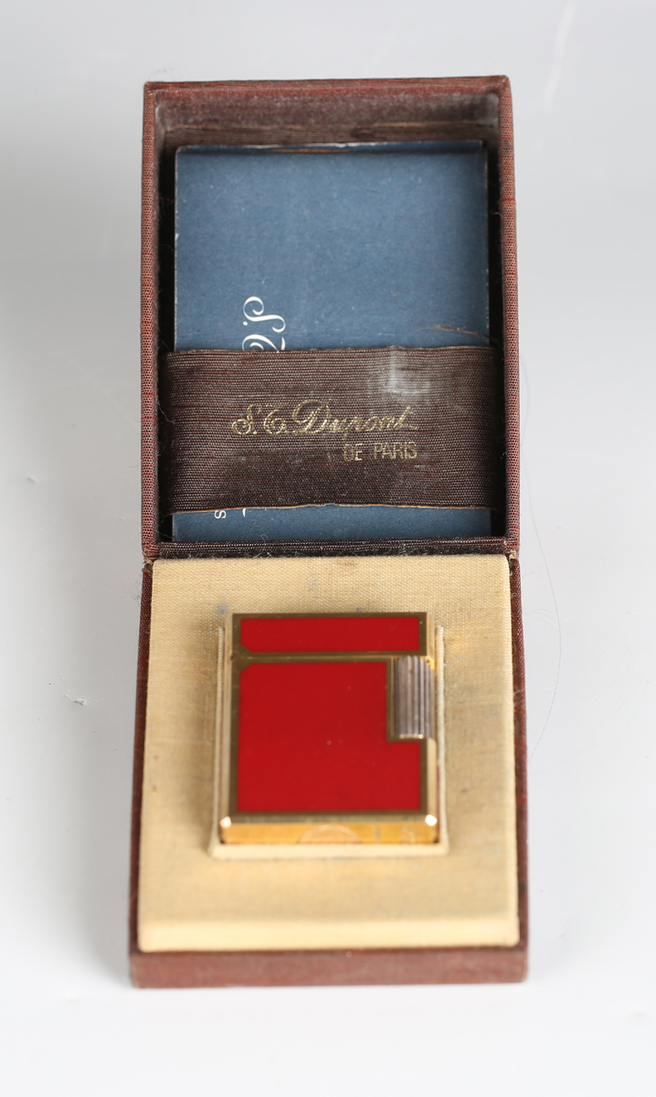 An S.T. Dupont Paris gilt metal and red enamel pocket lighter, detailed 'B5AG53', length 4.6cm,