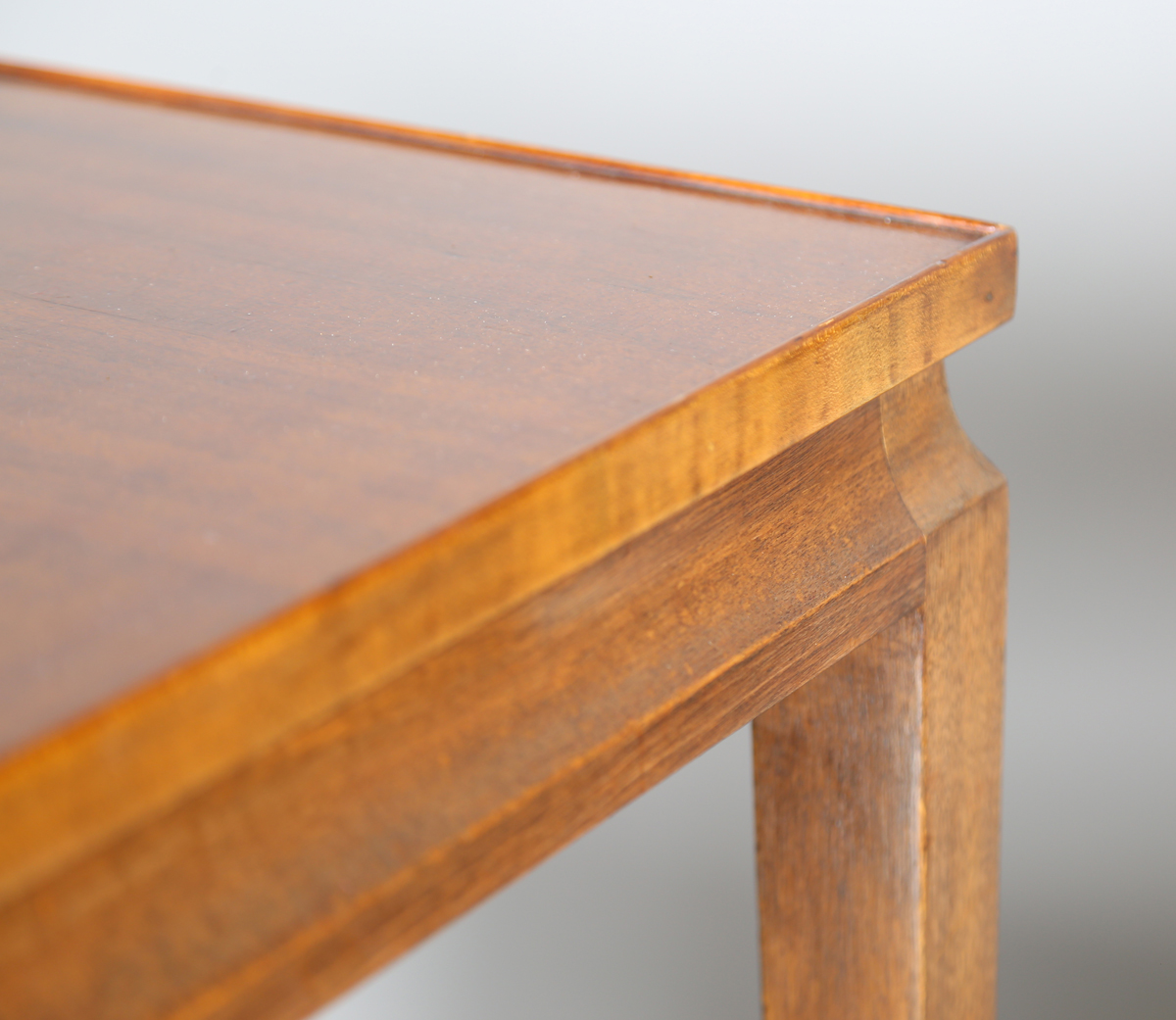 A pair of mid-20th century French mahogany lamp tables of retro design, the quarter-veneered tops - Image 3 of 8