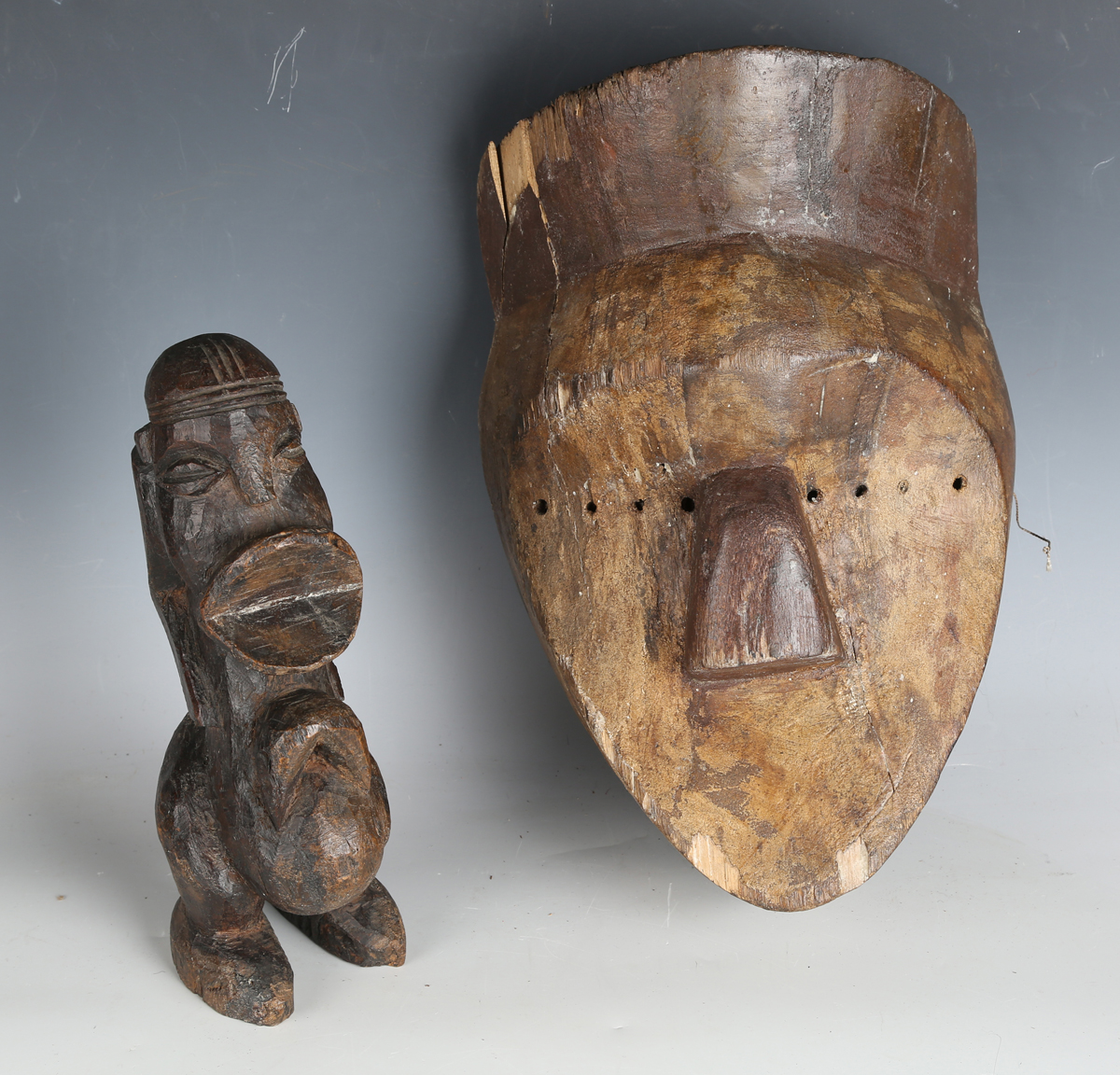 An African carved dense hardwood figure of stylized form, height 26cm, together with an African