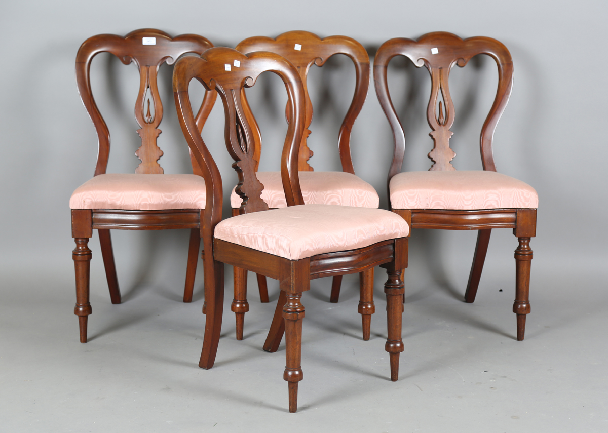 A set of four Victorian mahogany dining chairs, the shaped backs above upholstered drop-in seats, on