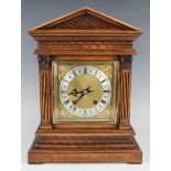 An early 20th century walnut cased mantel clock with eight day movement striking on a gong, the back