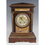 A late 19th century French brown patinated brass and porcelain mounted mantel clock with eight day