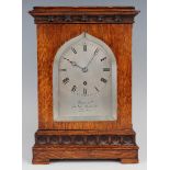 A late Victorian Gothic Revival oak cased mantel timepiece with eight day fusee movement, the