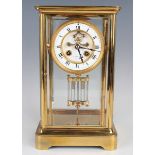 A late 19th century lacquered brass four glass mantel clock with eight day movement striking on a