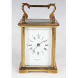 A 20th century lacquered brass carriage timepiece with eight day movement, the white enamelled