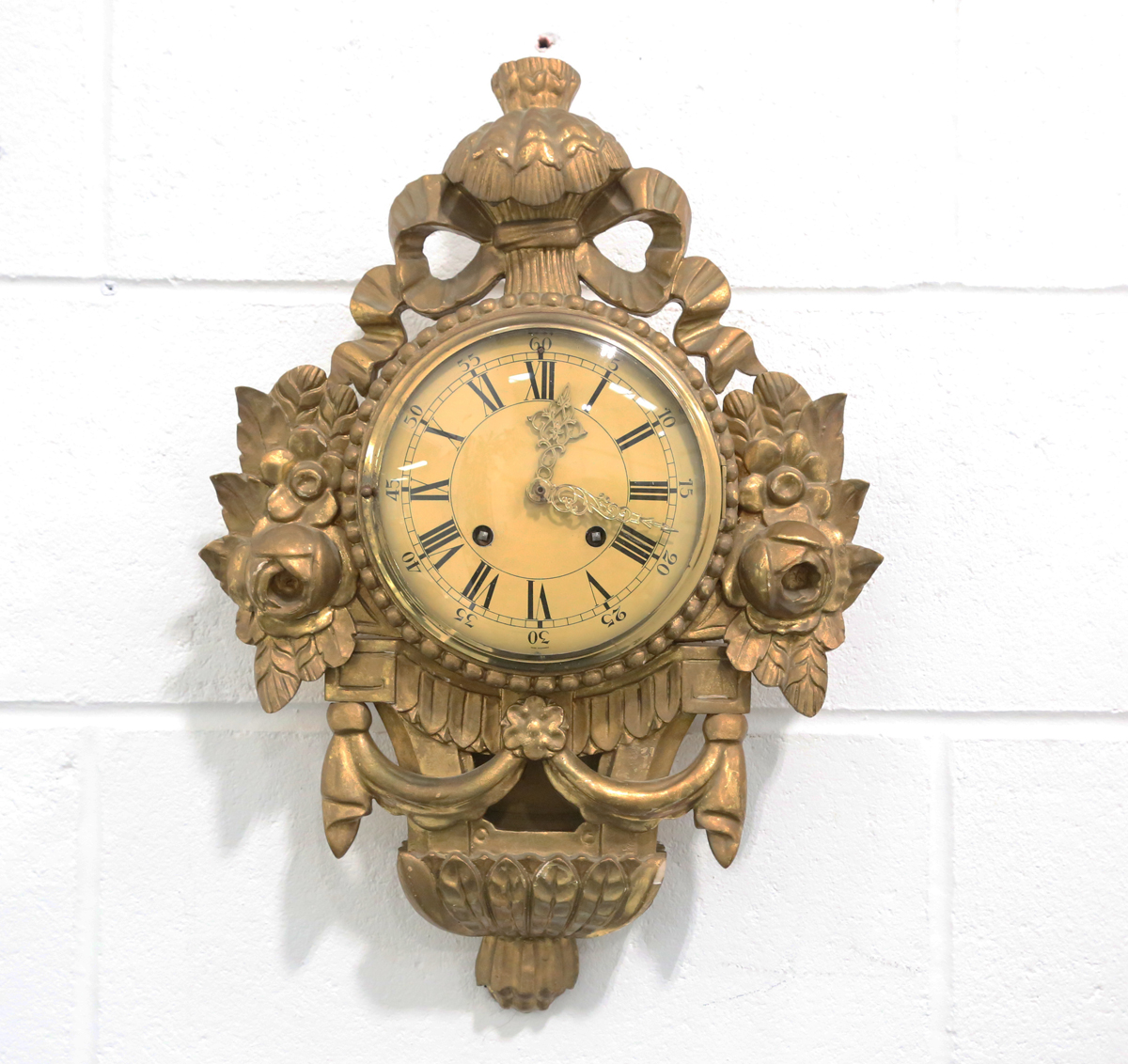 A mid-20th century giltwood and gesso cartel style wall clock with eight day movement striking on