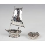 A late Victorian silver novelty salt in the form of a sailing boat with a figure seated at the helm,