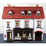 A doll's house baker's shop 'Crumble & Spice', the hinged dormer roof revealing a landing and two