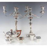 A group of plated items, including a pair of twin scroll branch three-light candelabra with