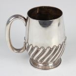 A Victorian silver christening tankard with half spiral reeded decoration and loop handle, on a