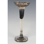 A George V silver square tapering vase with pierced scroll rim, on a flared everted corner square