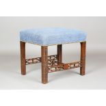 A George III Chinese Chippendale style mahogany stool, the overstuffed blue fabric seat on blind