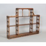 A 20th century Georgian Gothic style mahogany wall shelf with fretwork side supports and pierced