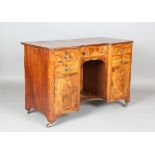A George III figured mahogany inverted breakfront kneehole desk with boxwood stringing and brass