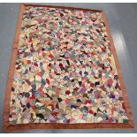 An early 20th century printed cotton patchwork quilt within a pink velour border, 155cm x 116cm.