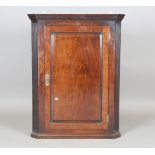 A George III mahogany hanging corner cabinet, the panelled door flanked by fluted sides, height