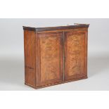 A George III figured mahogany two-door wall cabinet, height 52cm, width 61cm, depth 20cm.