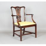 A George III Chippendale period mahogany elbow chair with a finely carved and pierced splat back,