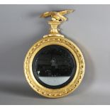 A Regency giltwood and gesso convex wall mirror with carved eagle surmount and ballshot mounted
