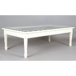 A 20th century white painted display case coffee table, the glass top enclosing a purple silk-