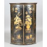 A George III black and gilt chinoiserie hanging corner cabinet, the two doors enclosing three claret