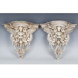 A pair of modern cast composition wall brackets of winged grotesque mask form, height 35cm, width