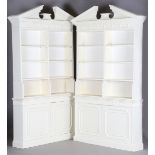 A pair of 20th century Neoclassical style white painted open bookcases, each break arch pediment