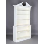 A 20th century Neoclassical style white painted open bookcase, the break arch pediment above open