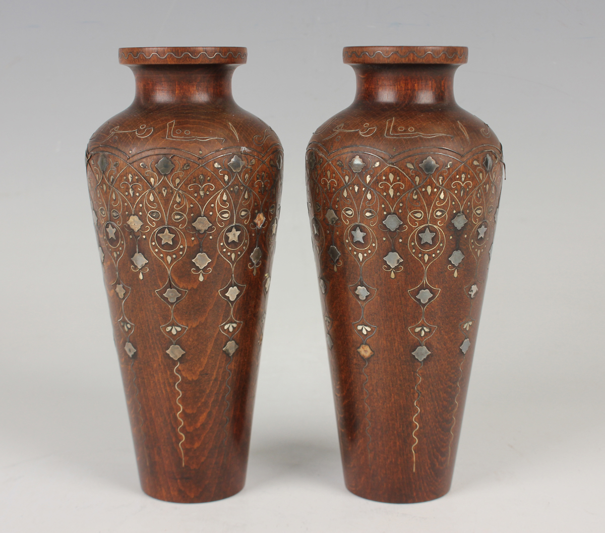 A pair of Islamic inlaid wooden vases, probably Syrian, early 20th century, each shouldered tapering