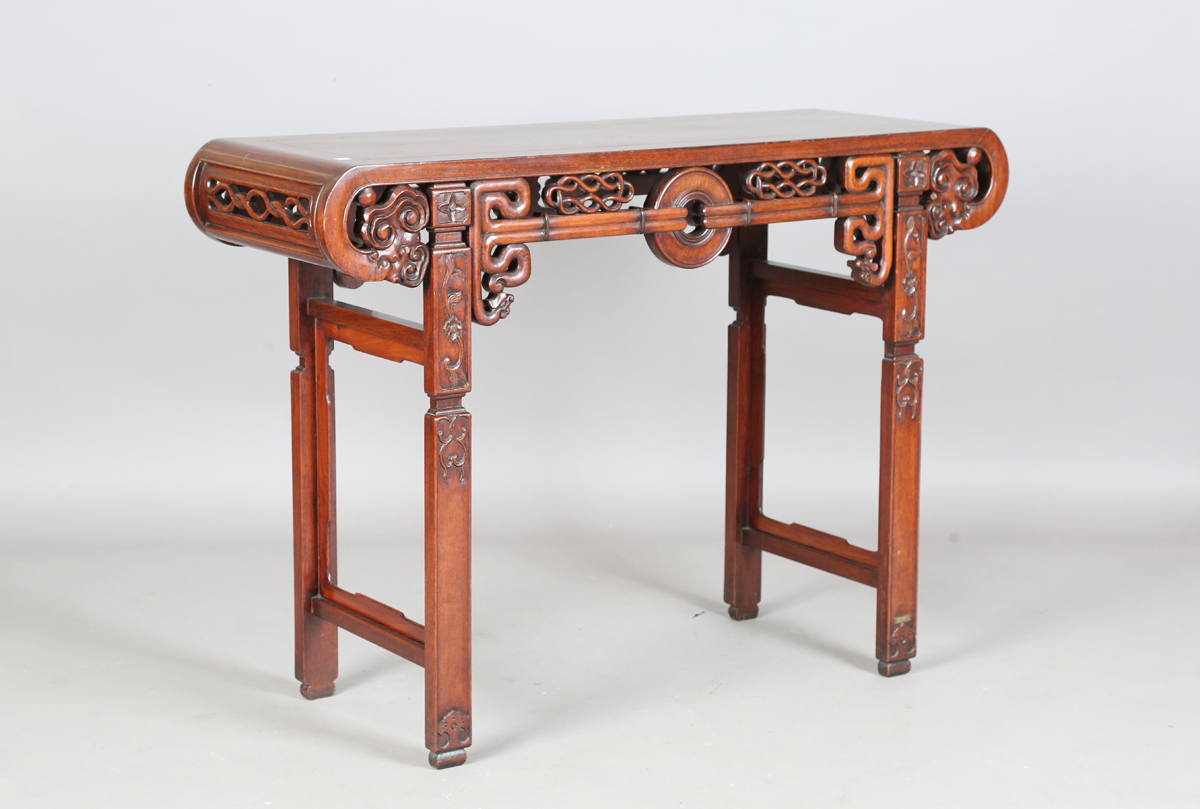 A Chinese hardwood altar table, 20th century, the rectangular panelled top with curved ends, the