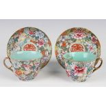 A pair of Chinese famille rose millefleurs porcelain cups and saucers, mark of Qianlong but probably