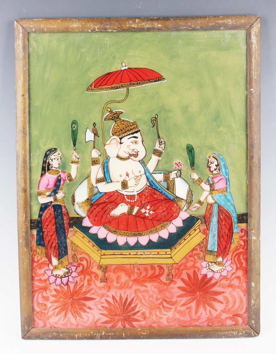 An Indian reverse painting on glass, late 19th/early 20th century, depicting Ganesh seated on a