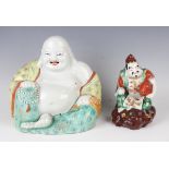 A Chinese porcelain figure of a seated smiling Buddha, early 20th century, modelled wearing an