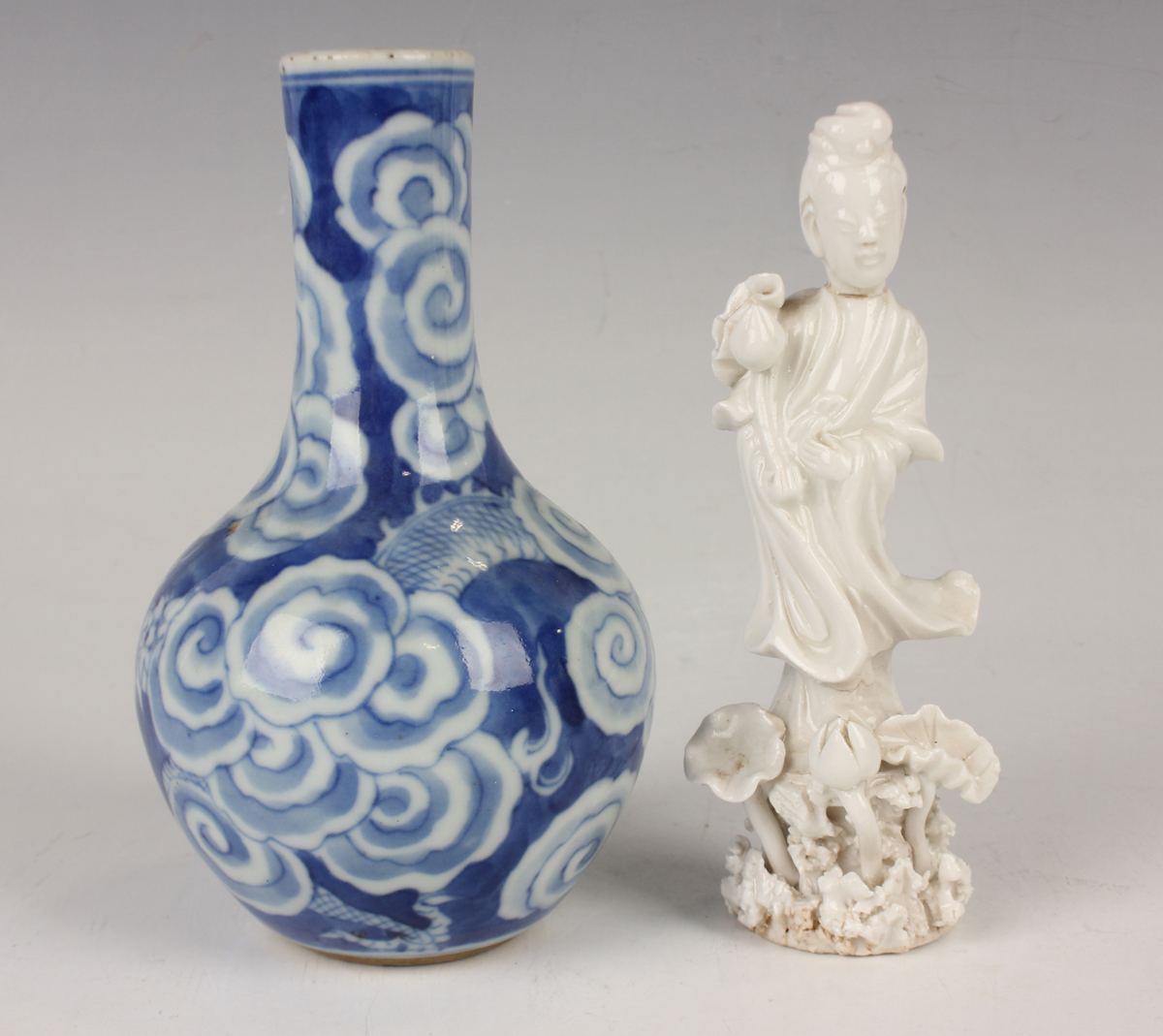 A Chinese blue and white porcelain bottle vase, Qing dynasty, painted with a dragon emerging through