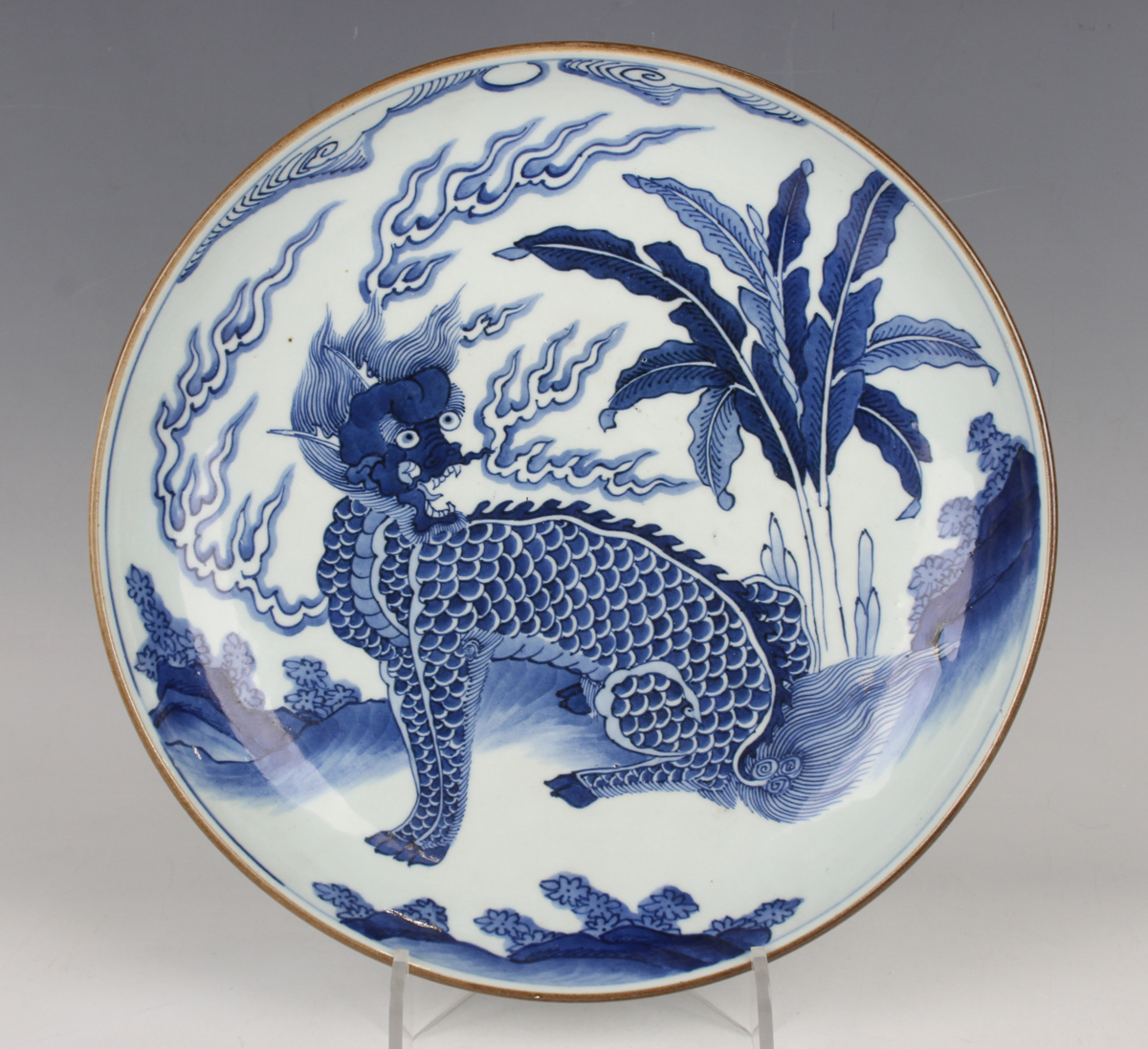 A Chinese blue and white porcelain circular dish, late Qing dynasty, painted with a seated kylin,