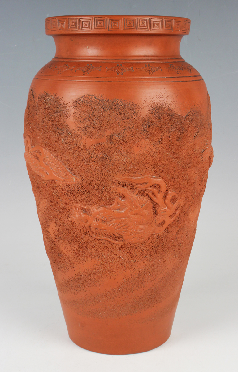 A Japanese red stoneware vase, Meiji period, of shouldered tapering form, modelled in relief with