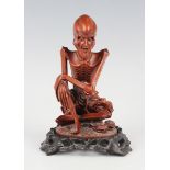 A Chinese carved boxwood figure of a seated arhat, late Qing dynasty, the skeletal figure wearing