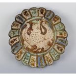 A Persian lustre pottery circular dish, possibly Kashan, 14th century, the centre painted with a