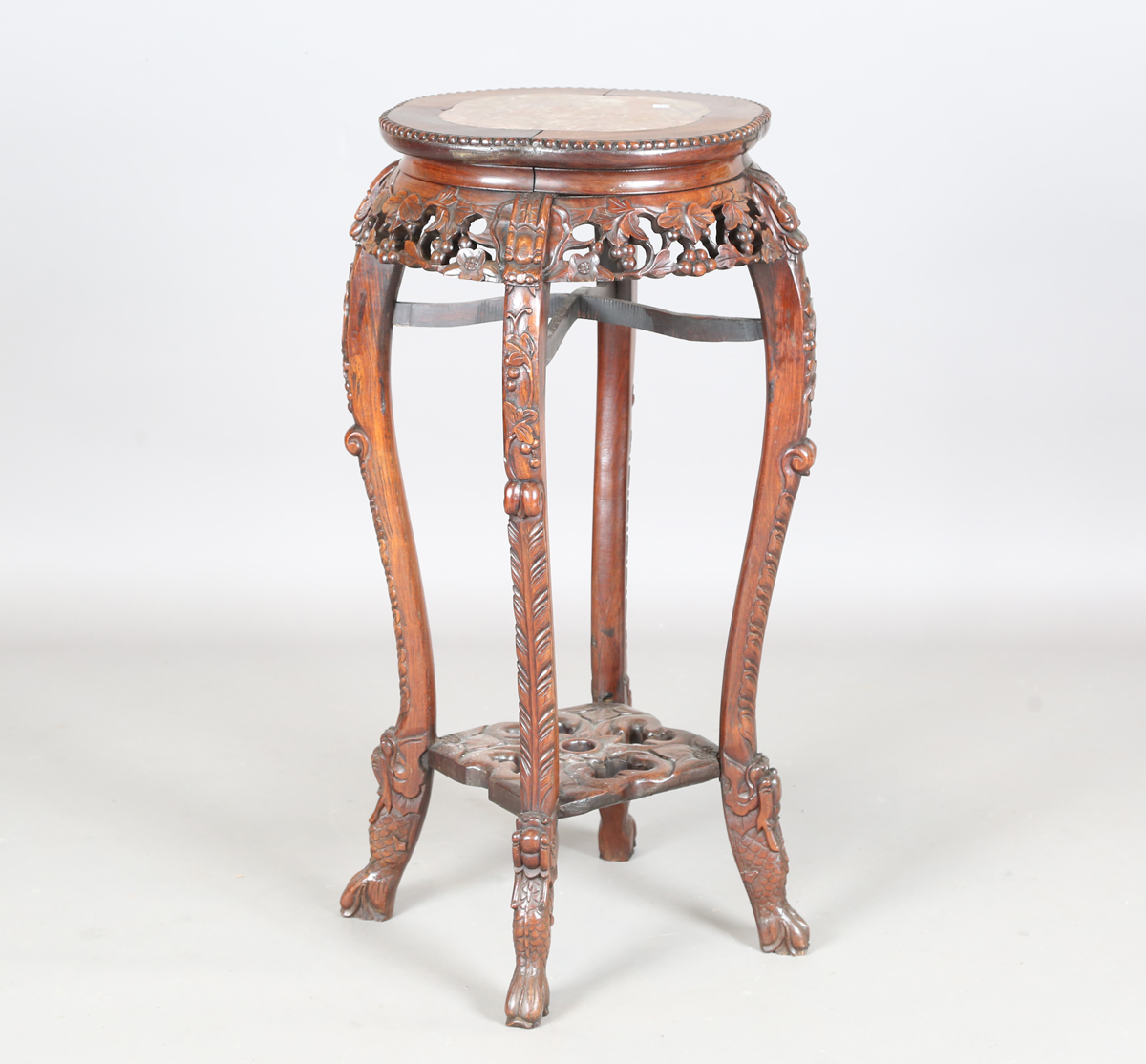 A Chinese hardwood jardinière stand, early 20th century, the quatrelobed top inset with a rouge