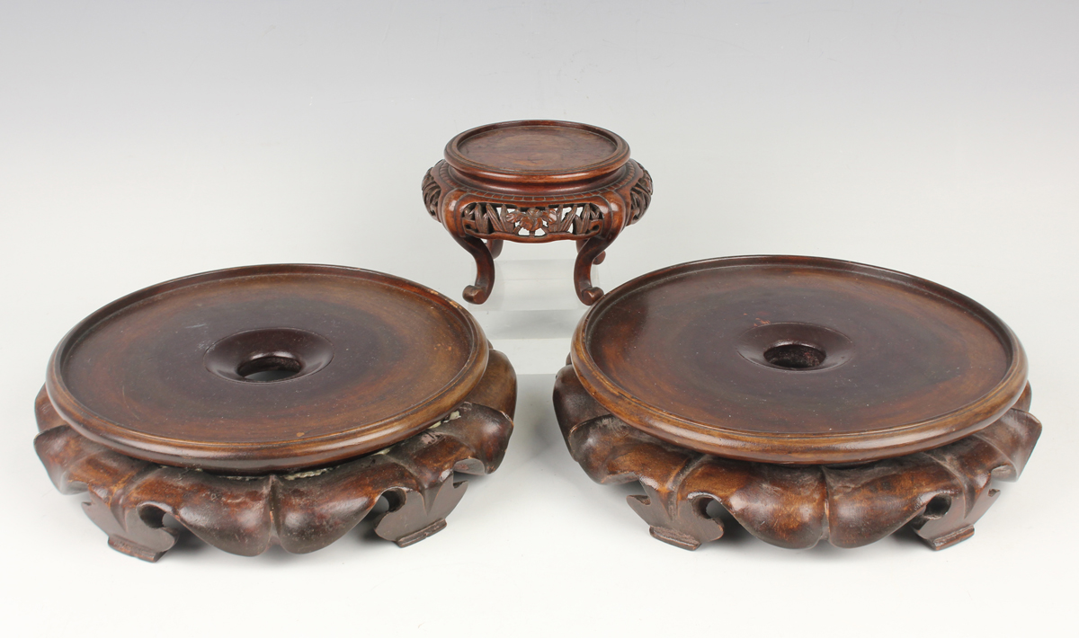 A collection of fourteen Chinese hardwood stands, 20th century, diameters ranging from 7.5cm to