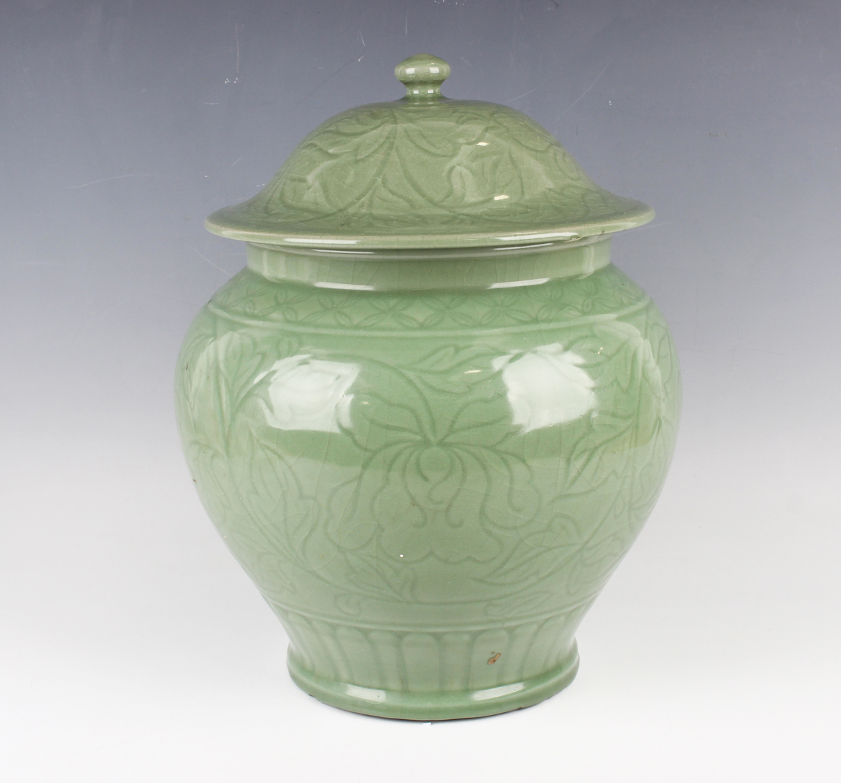 A Chinese carved celadon glazed jar and domed cover, Ming style but modern, carved in low relief