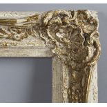 A 20th century swept painted and gilt composition frame of wide section, with foliate corner