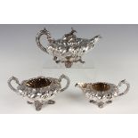 A William IV silver three-piece tea set of squat spiral lobed form, each shoulder chased with