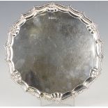 An Elizabeth II silver circular salver with scallop and gadrooned rim, on three paw feet,