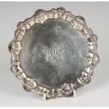 A George II silver card salver with engraved monogram to centre within a raised scroll and scalloped