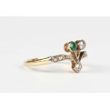 An Art Nouveau gold, diamond and emerald ring in an abstract design, mounted with two principal