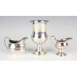 An Edwardian silver cushion shaped cream jug with reeded rim and angular handle, London 1909 by